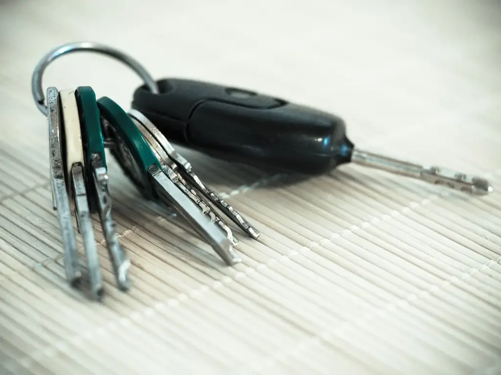 House keys and a calculator on a financial document, representing refinancing cost calculation