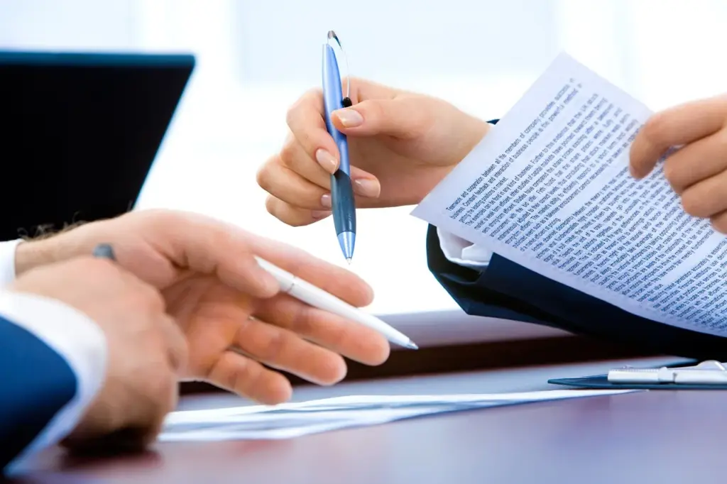 Man reading refinance paperwork with home loan documents